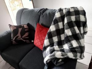 eine Decke auf einer Couch mit Kissen drauf in der Unterkunft Villa del Sol Margate in Margate