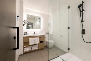 a bathroom with a glass shower and a sink at Sandman Signature Glasgow Hotel in Glasgow