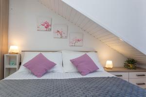 a bedroom with a bed with two purple pillows at Apartments Marija Bibić in Hvar