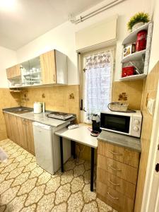 a small kitchen with a sink and a microwave at Apartment Kontrada in Umag