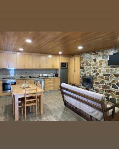a large kitchen with a table and a stone wall at Quinta da Recochina in Castro Daire +56 photos