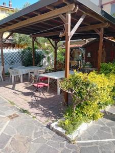 een picknicktafel en stoelen onder een paviljoen bij Mamita villa in Fiumicino