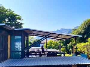 une personne assise sur une terrasse couverte d'une maison dans l'établissement Hailin Resort Vangvieng, à Vang Vieng