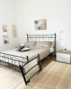 een slaapkamer met een bed met een zwart frame bij Marina Casa Vacanza in Capoterra