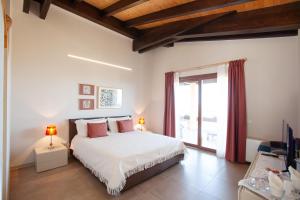 a bedroom with a bed and a large window at Le Tre Civette - Residenza di Campagna in Villa San Pietro