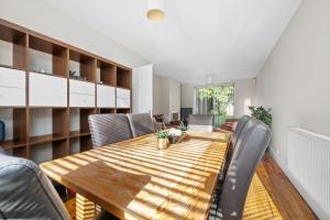 a dining room with a wooden table and chairs at Fantastic, modern 3 bedroom house in Manchester