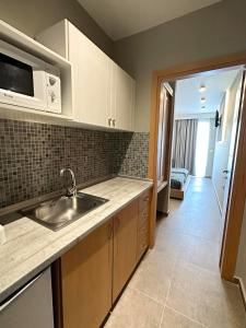 a kitchen with a sink and a microwave at Argiri Resort Hotel & Apartments in Kardamaina