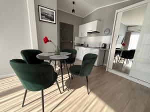 a kitchen and dining room with a table and chairs at Apartamenty BLAST nad morzem Chłopy in Chłopy