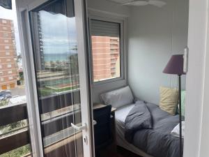 niewielka sypialnia z łóżkiem i oknem w obiekcie Apartamento frente al mar (Avda costa Blanca) w Alicante