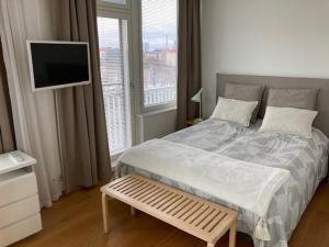 a bedroom with a bed with a television and a window at Alvar 114 in Helsinki