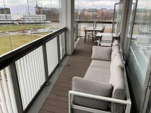 a balcony with a couch and a table with a view at Alvar 114 in Helsinki