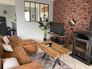 salon z kanapą, stołem i kominkiem w obiekcie Vintage house w mieście Giffaumont