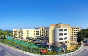 an apartment building with a tennis court in front of it at Studios in Sveta Elena complex with mineral pool in St. St. Constantine and Helena