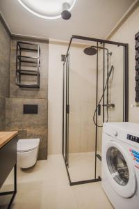 a bathroom with a washing machine and a shower at Dom Goscinny Bialy Dworek in Człuchów