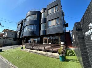 un gran edificio negro con un patio de césped delante de él en &HouSE - Vacation STAY 93911v, en Takagi