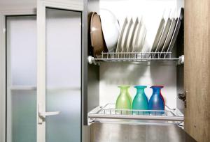 três vasos coloridos sentados numa prateleira num frigorífico em Light House Bisceglie em Bisceglie