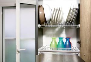three colorful vases sitting on a shelf in a refrigerator at Light House Bisceglie in Bisceglie