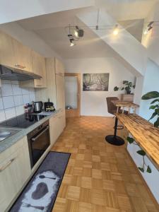 a kitchen with a wooden floor and a wooden table at Apartment inmitten der Stadt Leoben. in Leoben