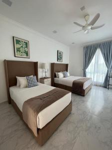 a bedroom with two beds and a ceiling fan at The Arjana Resort in Masjid Tanah