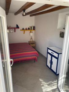 een kleine slaapkamer met een bed en een tafel bij Casa Lilian in Stromboli