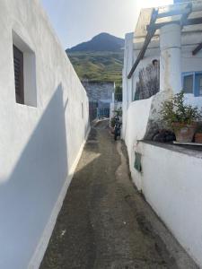een steegje met witte gebouwen en een berg op de achtergrond bij Casa Lilian in Stromboli