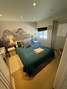 - une chambre avec un grand lit et une couverture bleue dans l'établissement Charming one bedroom cottage, à Basingstoke