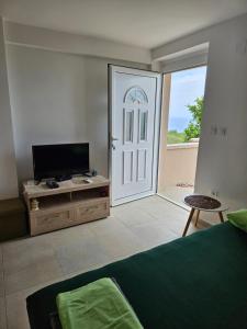 a living room with a television and a door to a patio at Apartment Cezar in Krimovice
