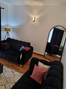 a living room with two couches and a mirror at Rossyln Home close to Village Market, UN and Two Rivers Mall in Nairobi