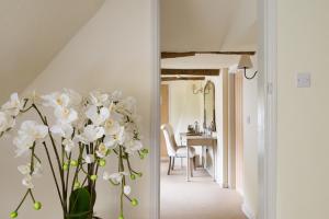 a vase with white flowers in a hallway at Kings Head Bawburgh in Norwich
