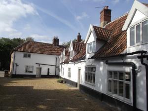 a group of white buildings with a courtyard at Kings Head Bawburgh in Norwich