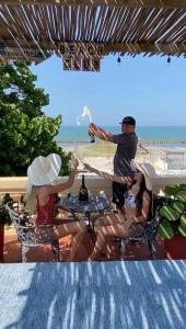 um grupo de pessoas sentadas em torno de uma mesa em um pátio em Hotel Boutique Castillo Ines Maria em Cartagena das Índias