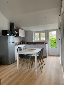 a kitchen with a table and chairs in a room at Les Apparts de St Mart in Bréhal