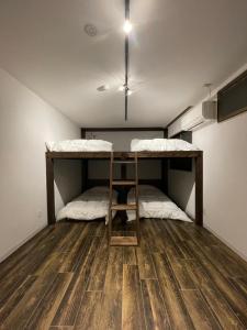 two bunk beds in a room with a wooden floor at &HouSE - Vacation STAY 72442v in Takagi