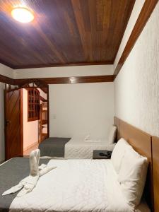 - une chambre avec deux lits et un plafond en bois dans l'établissement Hotel Fazenda Tucano, à Capim Branco