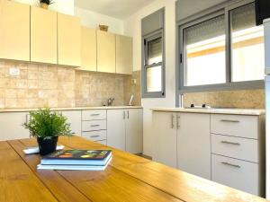 a kitchen with a wooden table with a book on it at Two Bedrooms Duplex Apartment l Bugrashov Street l by Bookiz in Tel Aviv