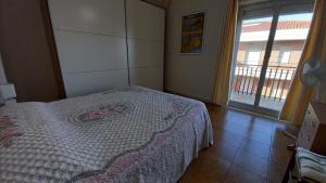 Schlafzimmer mit einem Bett und einem Fenster mit einem Balkon in der Unterkunft Bilocale Jonio in Mascali