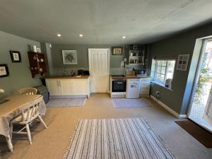 - une cuisine avec des murs verts, une table et une cuisinière dans l'établissement Charming one bedroom cottage, à Basingstoke