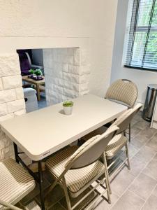 un tavolo bianco e sedie in soggiorno di Purple Blossom, cosy 2 bed apartment, near Didsbury, free parking a Manchester