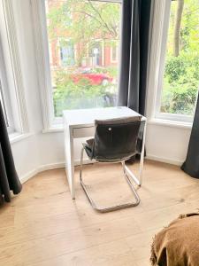 a white desk with a chair in front of a window at Purple Blossom, cosy 2 bed apartment, near Didsbury, free parking in Manchester