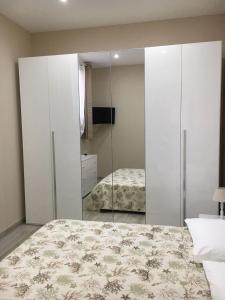 ein Schlafzimmer mit einem Spiegel und einem Bett in der Unterkunft Casa Vacanze San Giacomo App Perla in Santo Stefano al Mare