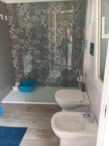 Ein Mann fotografiert ein Bad mit Dusche in der Unterkunft Casa Vacanze San Giacomo App Perla in Santo Stefano al Mare