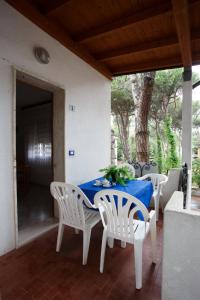- une table et des chaises sur la terrasse couverte d'une maison dans l'établissement Villa Zanella, à Rosolina Mare