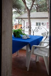 une table avec un chiffon bleu sur une terrasse dans l'établissement Villa Zanella, à Rosolina Mare