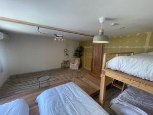 1 dormitorio con 2 camas, mesa y silla en &HouSE - Vacation STAY 52186v, en Takagi