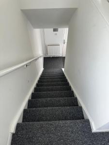 a staircase in an empty room with grey carpet at Iyanla HOuse in Middleton