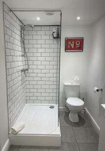 y baño blanco con ducha y aseo. en Apartment 1 St Georges, en Cheltenham