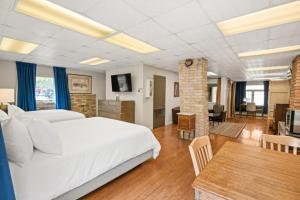 Hotel Maxwell Anderson في غلينوود سبرينغز: غرفة نوم بسرير كبير وغرفة طعام