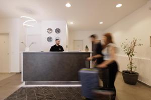 a man and a woman standing behind a counter at Local Hostel & Suites in Corfu