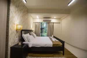 sypialnia z dużym łóżkiem i oknem w obiekcie Villa Cozy - Luxury Plunge Pool Villa in South Goa w mieście Benaulim