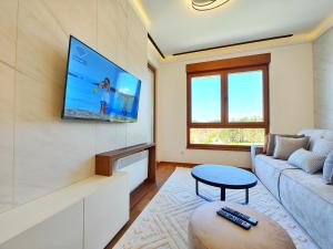 un soggiorno con divano e TV a parete di Velika Recepcija CC Magnet a Zlatibor